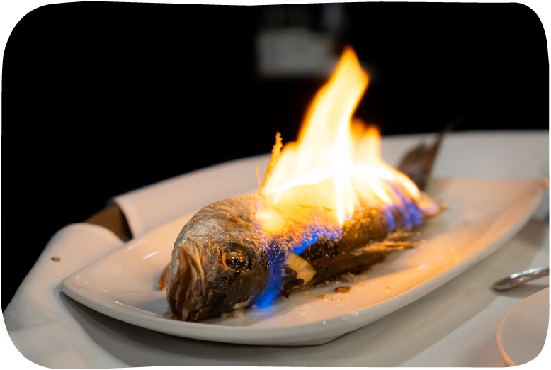 Flaming fish dish on a white plate