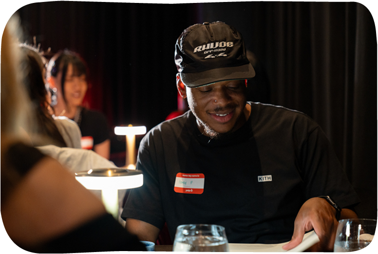 Man with cap and name tag at a social event