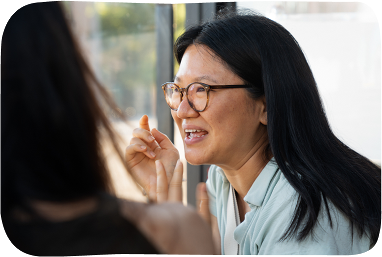 Woman with glasses in light blue top talking